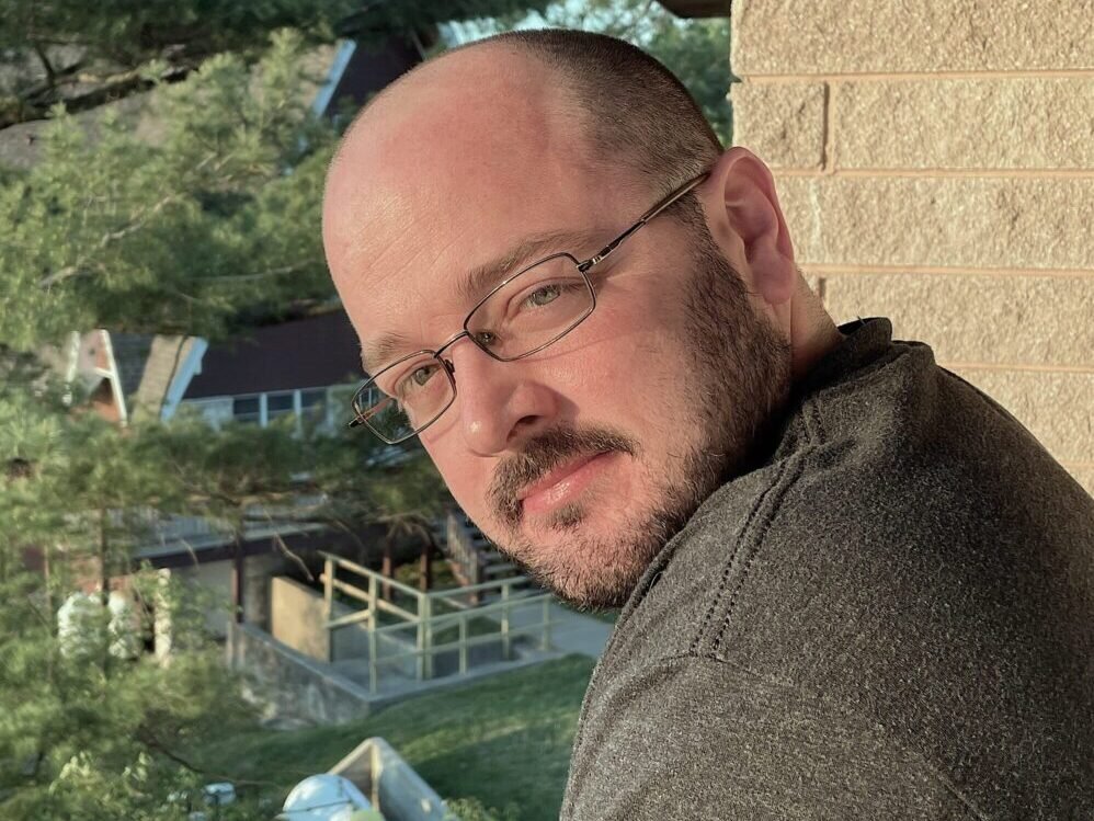 Host Ben leaning on a balcony.