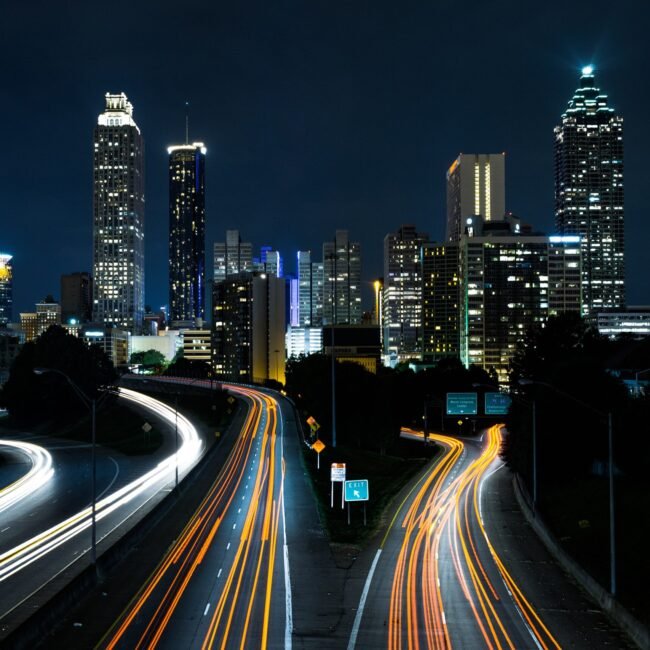 Cars driving on roads in a city at night.