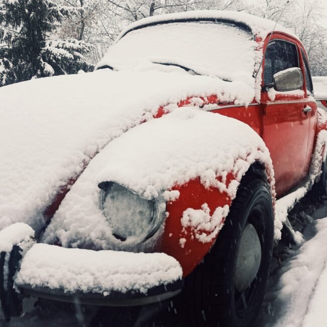 Red car covered in snow.